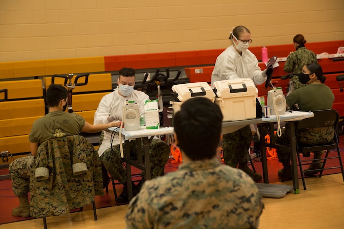 U.S. Marines wait their turn to donate blood during an Armed Services Blood Program (ASBP) blood drive at Hopkins Gymnasium on Camp Elmore, Norfolk, Virginia, May 28, 2020.