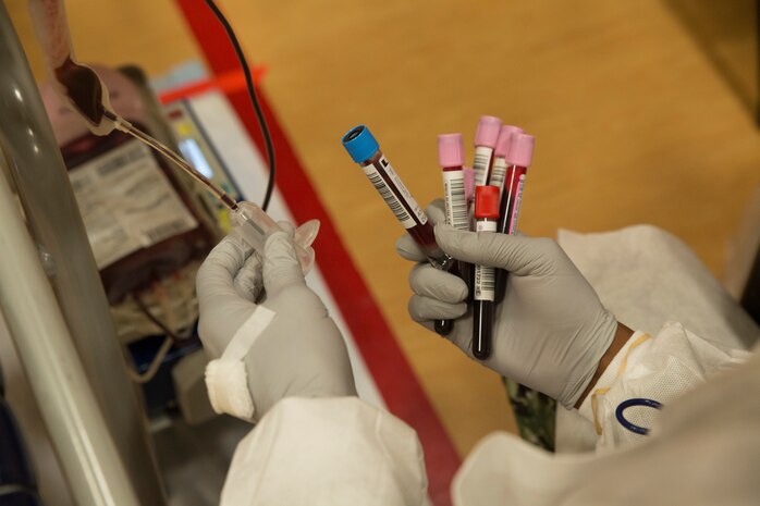 A U.S. Navy corpsman holds a vacutainer blood collection tube containing blood during an Armed Services Blood Program (ASBP) blood drive at Hopkins Gymnasium on Camp Elmore, Norfolk, Virginia, May 28, 2020.