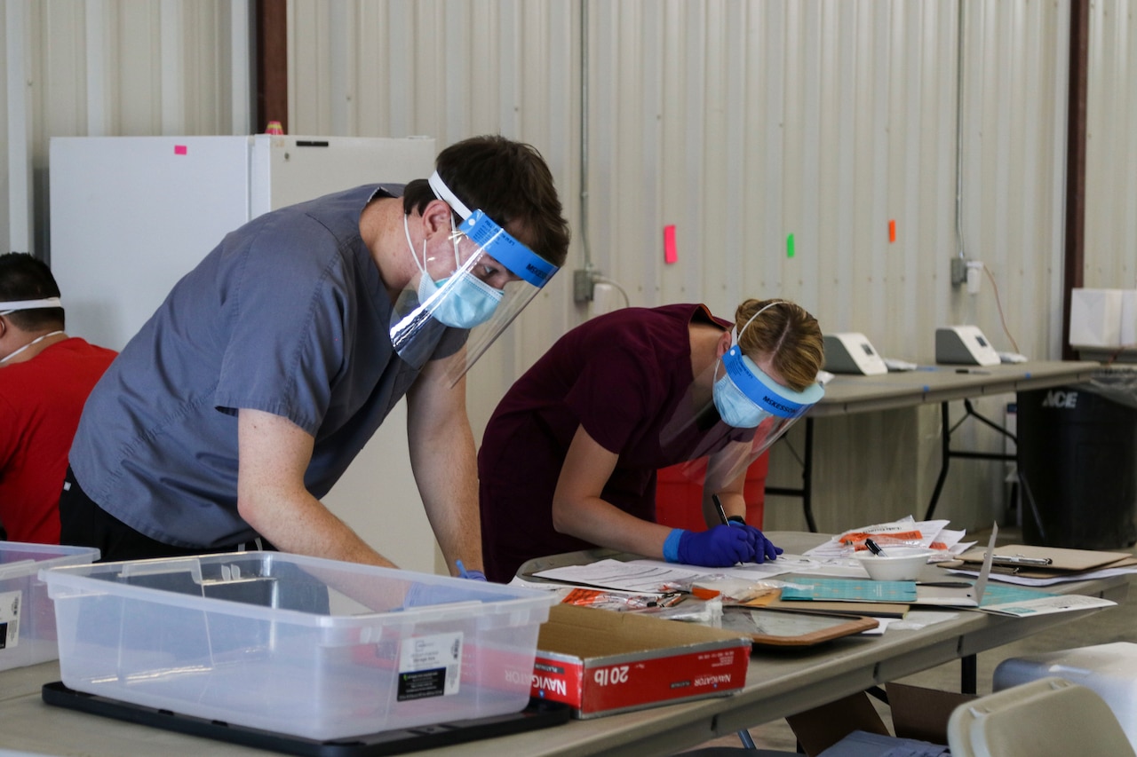 Kansas guardsmen conducting COVID-19 screenings.