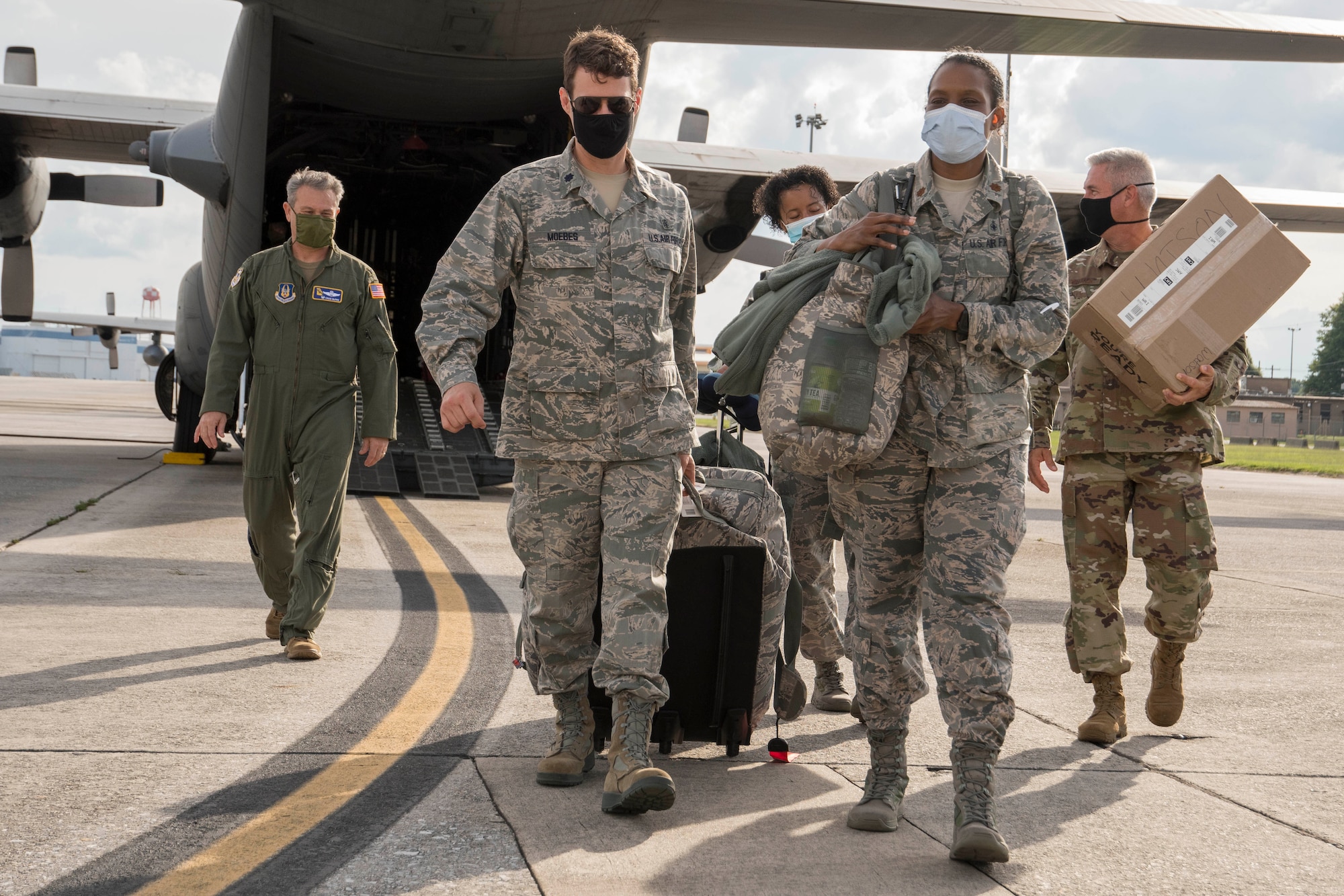 Nurses from the 94th Aeromedical Staging Squadron and members of the greeting party, including Col. Craig McPike, 94th Airlift Wing commander, left, depart a C-130H3 Hercules on the flightline at Dobbins Air Reserve Base, Ga. May 28, 2020. Four nurses from Dobbins mobilized to the COVID-19 frontlines in New York City as part of the whole-of-government response to the pandemic. (U.S. Air Force photo/Andrew Park)