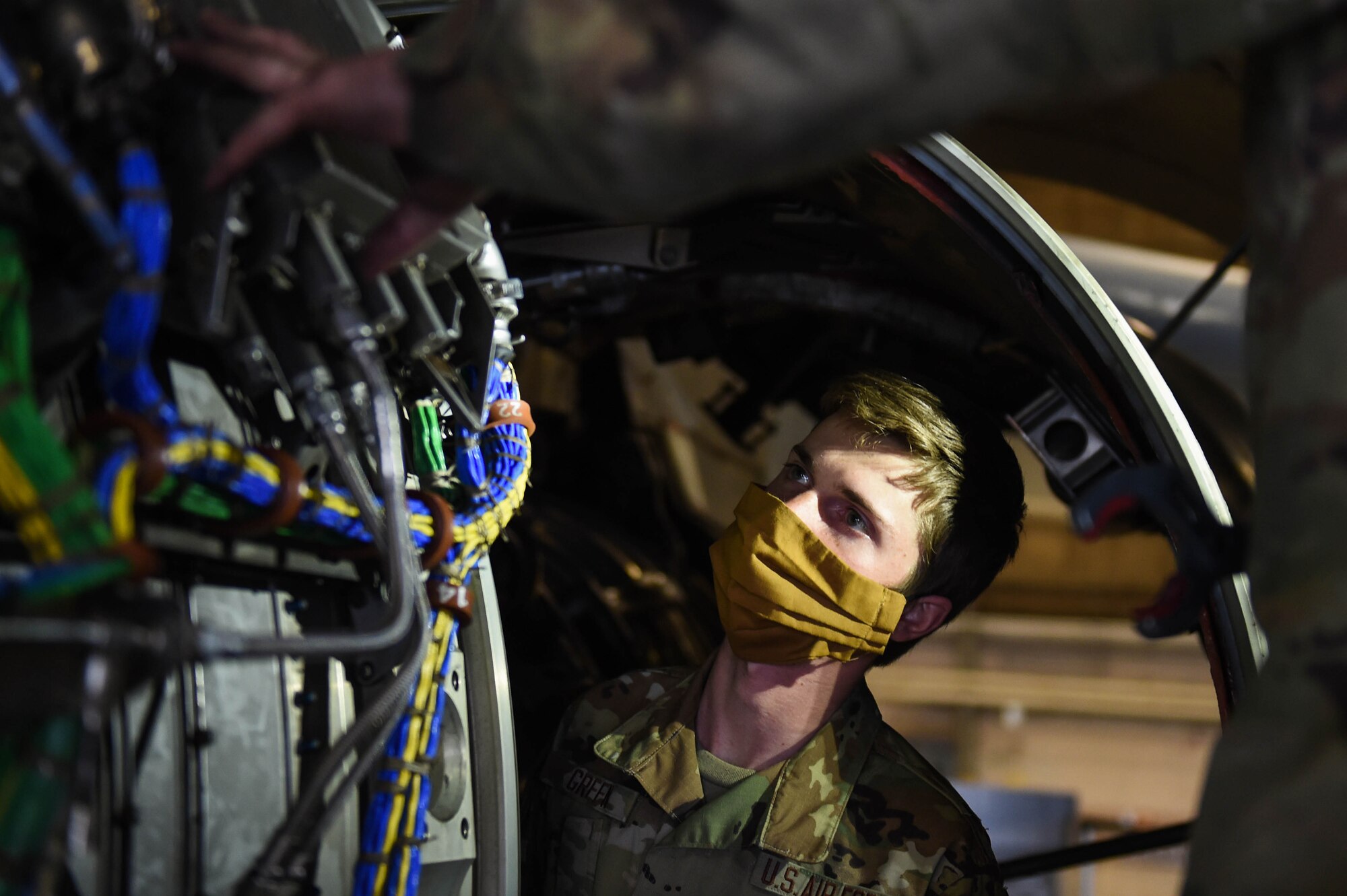 Airman 1st Class Jerrert Green receives training from Staff Sgt. Jonathan Daniels, both 62nd Maintenance Squadron jet mechanics, on the engine of a C-17 Globemaster III on Joint Base Lewis-McChord (JBLM), Wash., May 20, 2020. Airmen have still arrived to their first duty stations during the COVID-19 pandemic and units at JBLM have made it a priority to make sure they are integrated into their new units and start receiving training. (U.S. Air Force photo by Airman 1st Class Mikayla Heineck)