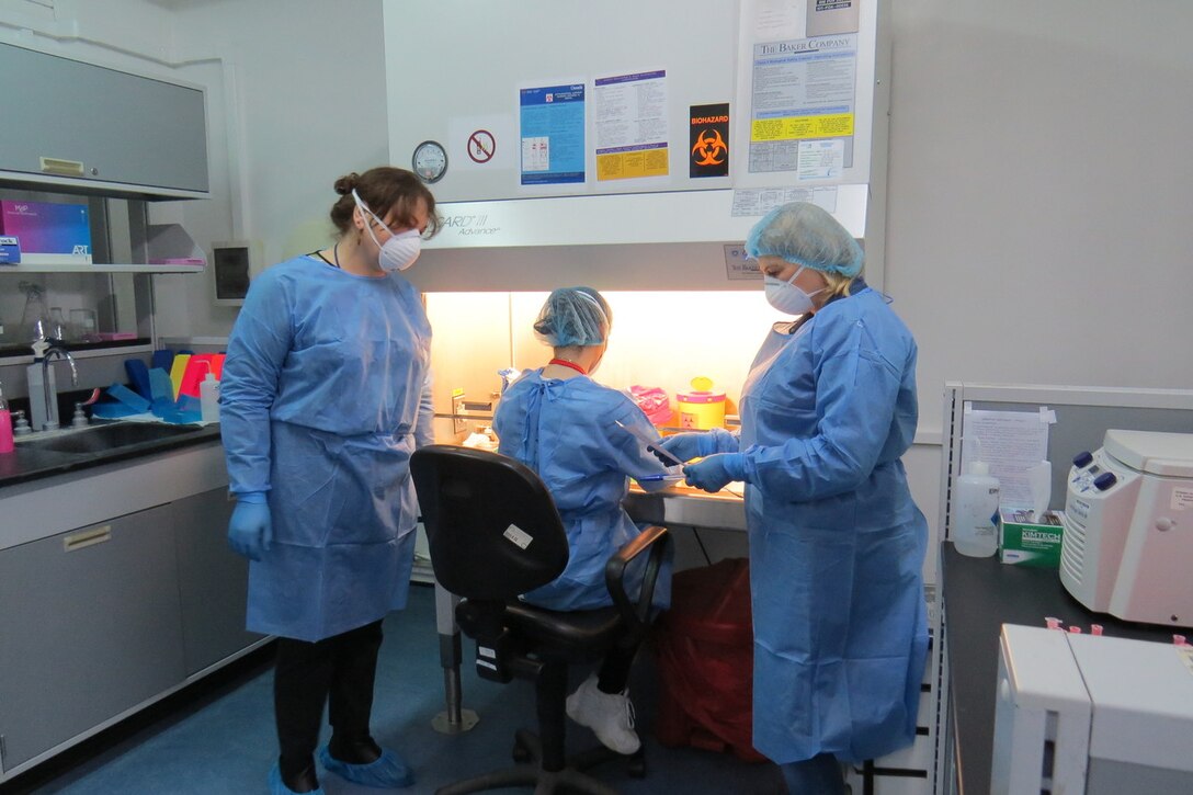 Laboratory technicians handle a potentially dangerous pathogen using a biosafety cabinet at the Republic of Georgia's central reference lab in Tbilisi, Georgia.