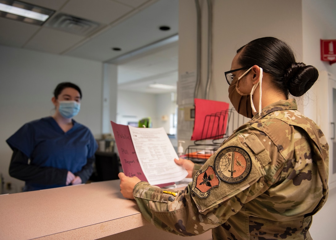 Tech. Sgt. Sara Moreno review a patient's form