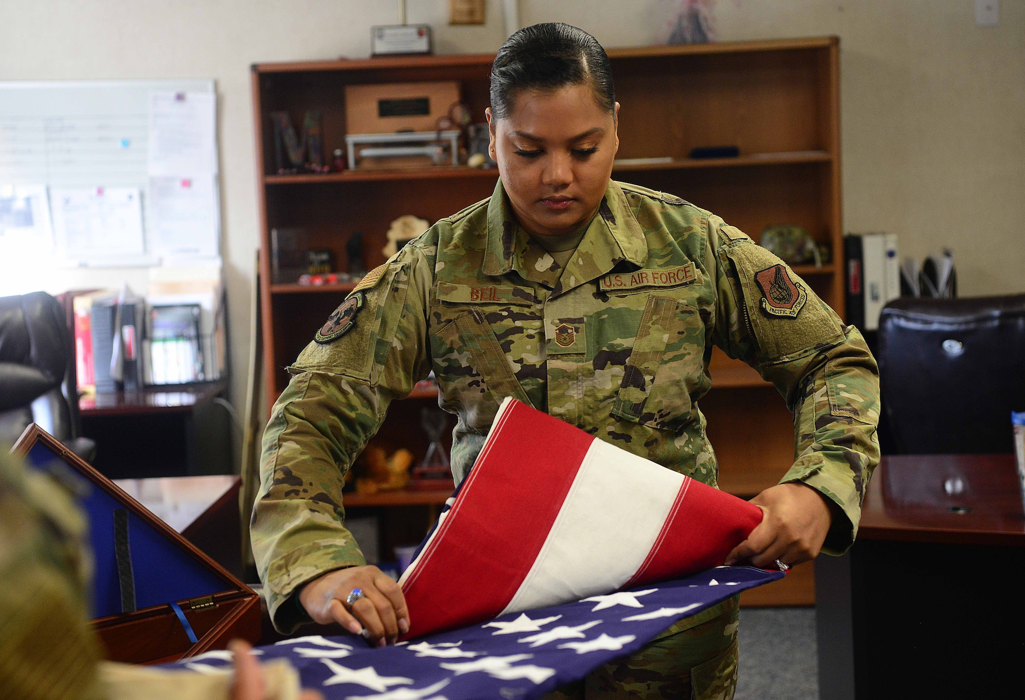 U.S. Air Force Master Sgt. Stephanie Beil, the 354th Force Support Squadron operations flight superintendent, folds a flag at Eielson Air Force Base, Alaska, June 1, 2020. Beil recently won Pacific Air Forces Force Support Squadron Senior Noncommissioned Officer of the Year at the installation level. (U.S. Air Force photo by Staff Sgt. Sean Martin)