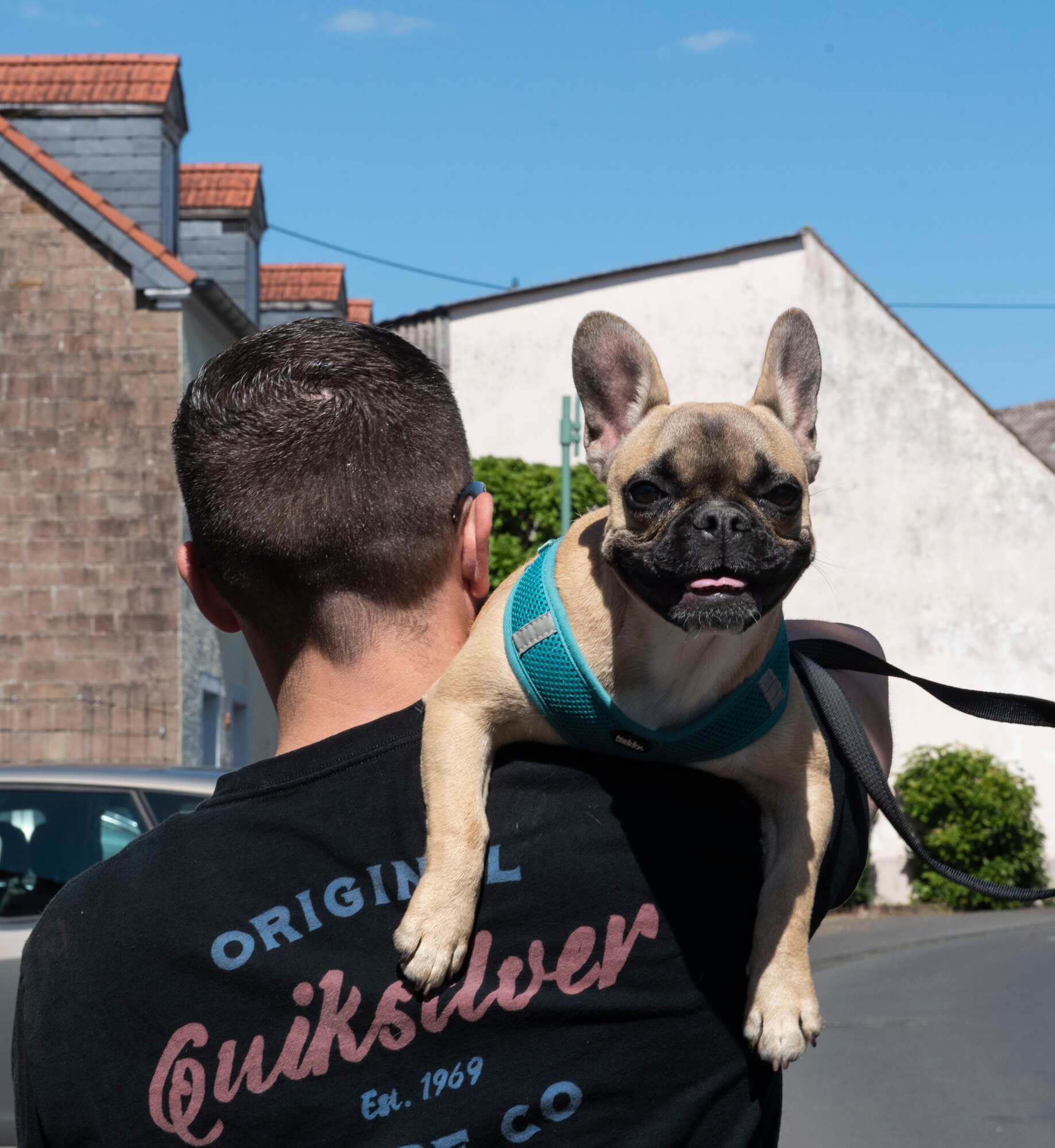 U.S. Air Force Staff Sgt. Sean Howley, 52nd Civil Engineer Squadron Fire and Emergency Services driver operator, carries his dog, Lily, during the walk around Spangdahlem, May 29, 2020. The six-kilometer walk allowed families to bring their dogs, and enjoy the fresh air and exercise while learning about the historical sites inside the village. (U.S. Air Force photo by Senior Airman Melody W. Howley)