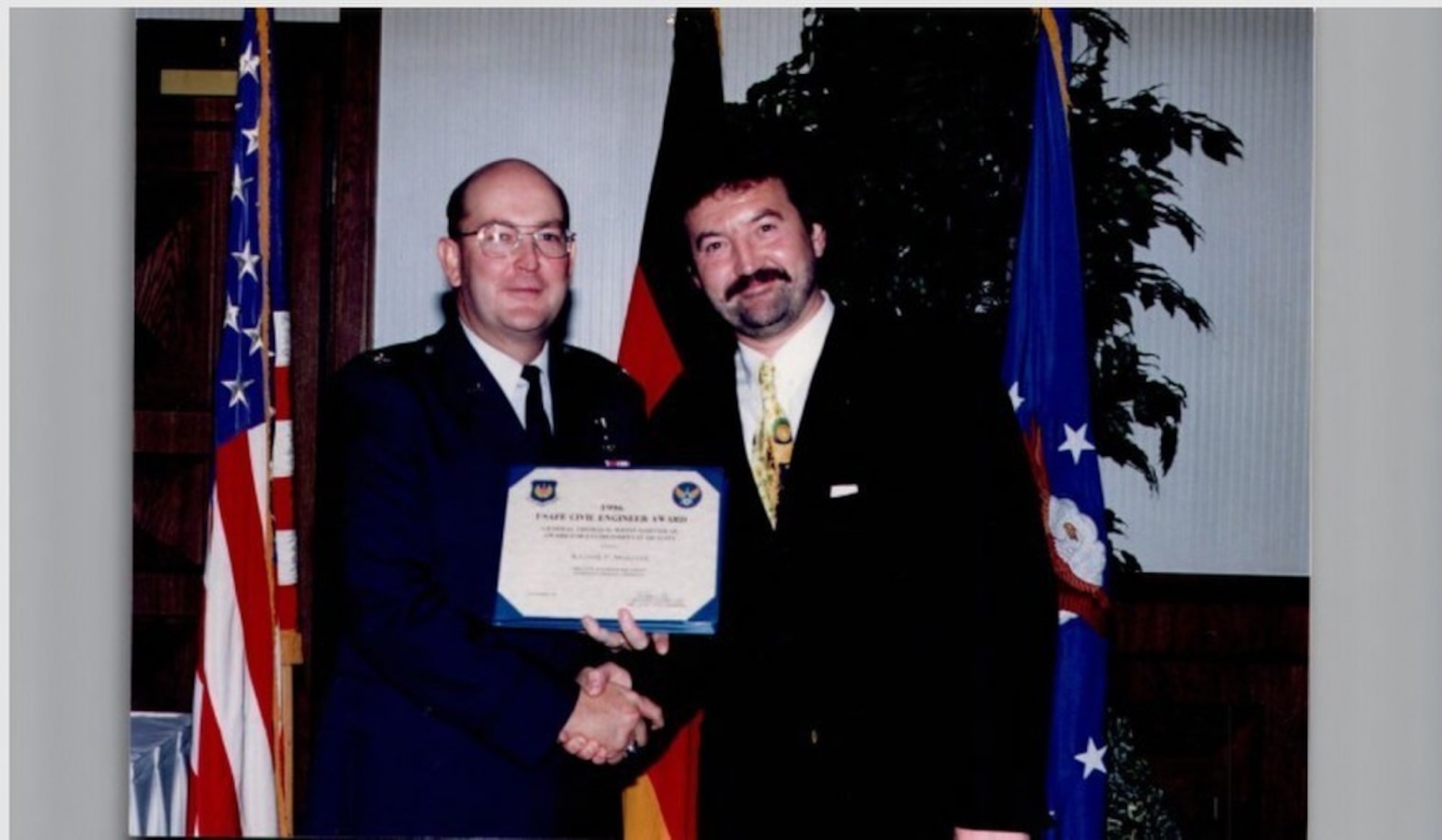 Mr. Rainer Mueller (right), 86th Civil Engineer Squadron installation management flight chief poses for a photo with retired Brig. Gen. Charles Fox after receiving the United States Air Forces in Europe Civil Engineer Award at Ramstein Air Base, Germany, 1996. Within 86th CES, Mueller put all of his attention into mitigating the base's environmental impact; and did so with great success. (Courtesy photo by Herr Rainer Mueller)