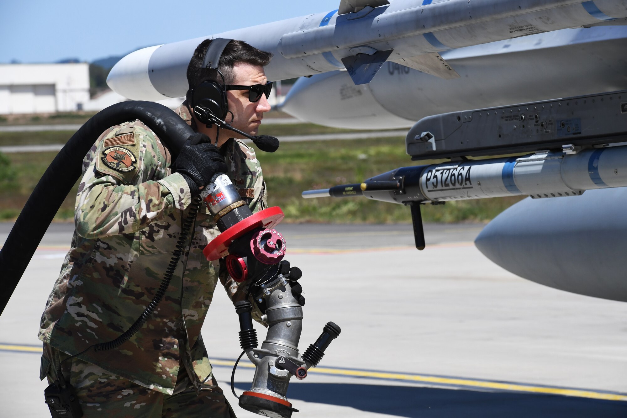 U.S. Air Force Master Sgt. Jayson Lyons, 435th Contigency Response Group readiness and training flight chief, brings a fuel hose to an F-16 Fighting Falcon during Exercise Agile Wolf at Ramstein Air Base, Germany, May 28, 2020. The exercise tested the ability to perform a "hot-pit refuel" during a contingency operation. (U.S. Air Force photo by Airman 1st Class Alison Stewart)