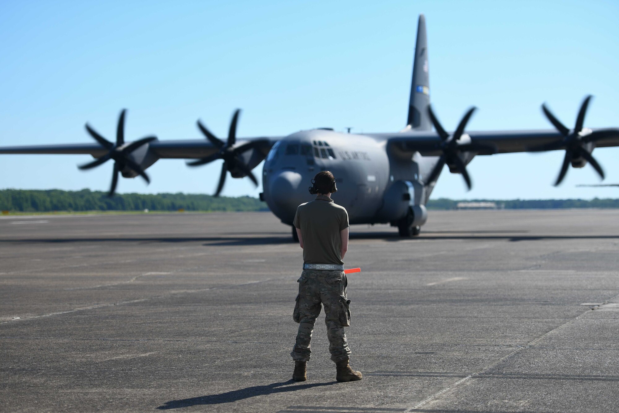 An Airman from the 314th Aircraft Maintenance Squadron prepares to marshal a C-130J Super Hercules to the runway at Little Rock Air Force Base, Arkansas.