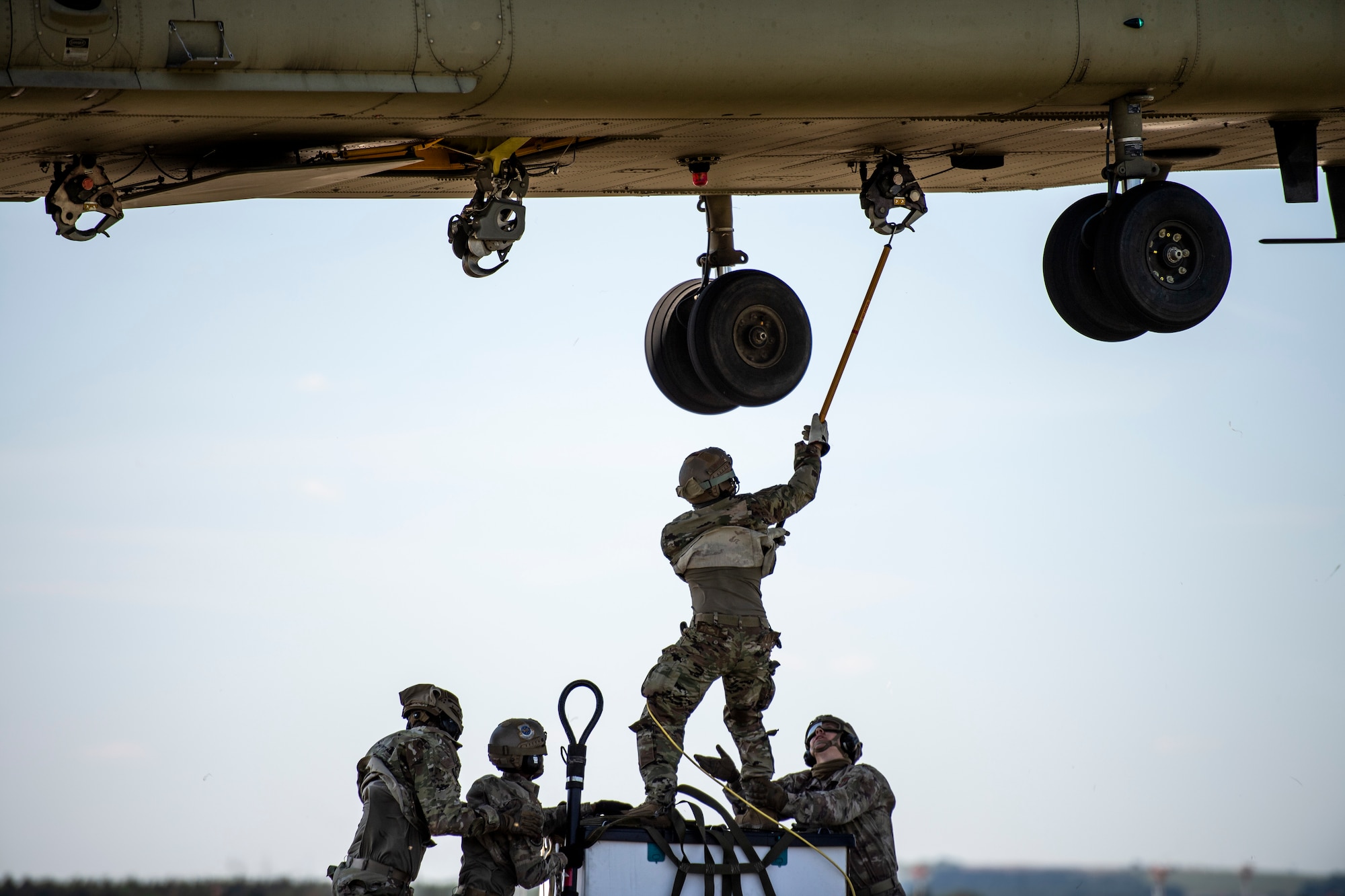 Photo of Airmen sling loading cargo to a helicopter