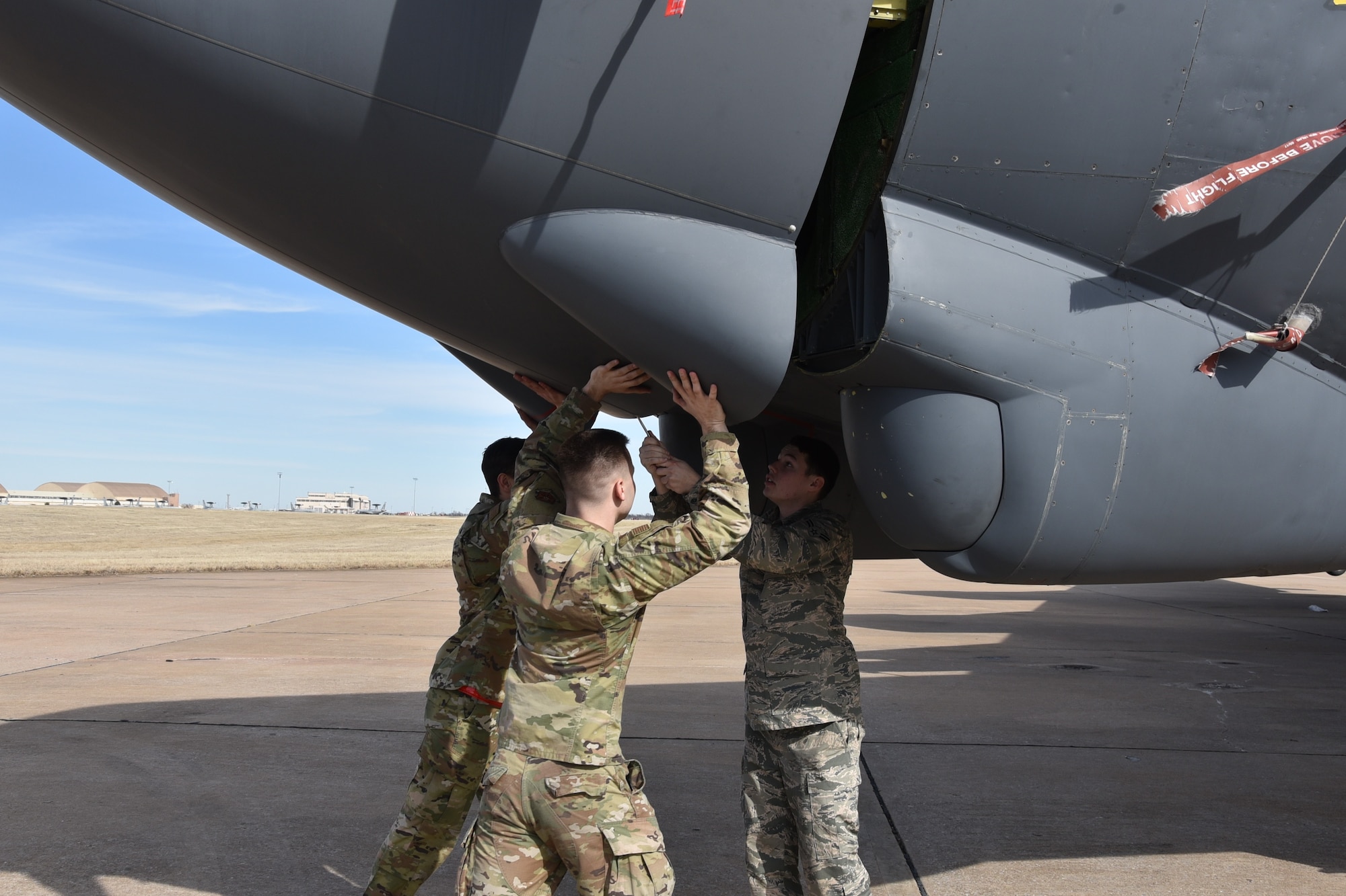 From left, Airman 1st Class Dominik Sticha, Staff Sgt. Derrick Ewing and Staff Sgt. Dylan Tuckett, maintainers with the 5th Aircraft Maintenance Squadron, Minot Air Force Base, North Dakota, close a nose radome on a B-52H Stratofortress bomber from the 2nd Bomb Wing, Barksdale AFB, Louisiana, on Jan. 27.   The aircraft is undergoing electromagnetic pulse hardness testing at the Compass Rose facility here. (U.S. Air Force photo/Ron Mullan)