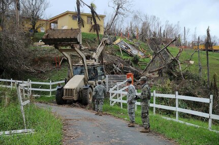 Citizen-Soldiers of the 190th Engineer Battalion, 101st Troop Command, Puerto Rico Army National Guard, clear debris in Cayey Sept. 30, 2017, after Hurricane Maria caused heavy damage throughout the region. Fallen trees, power lines and debris kept the community isolated for days.