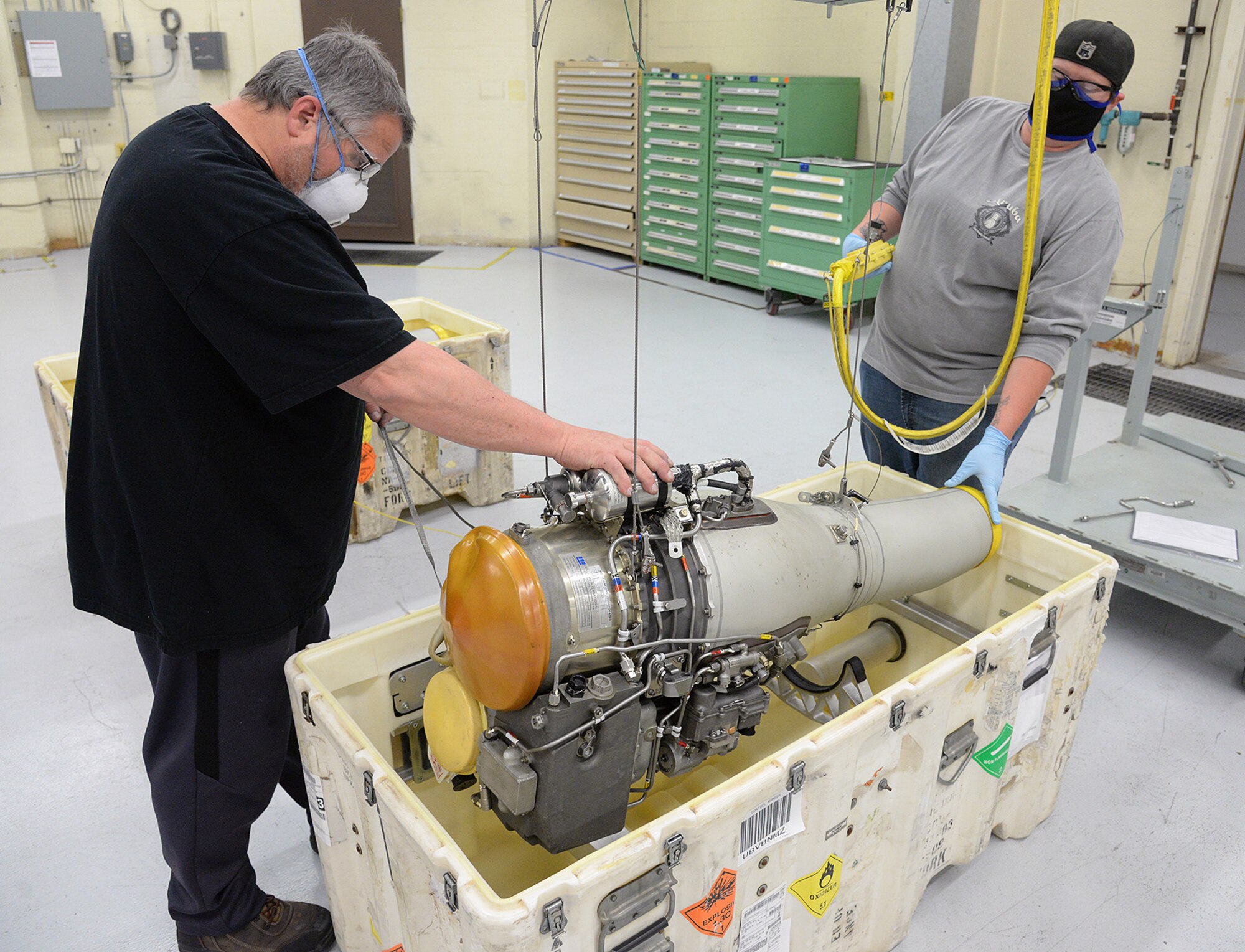 582 Missile Maintenance Squadron liquid engine rocket fuel mechanics, Kevin O’Donnell (left) and Jennifer McClellan, maintain their social distance while placing an F-107 turbofan engine into a shipping container on Apr. 28, 2020, at Hill Air Force Base, Utah.