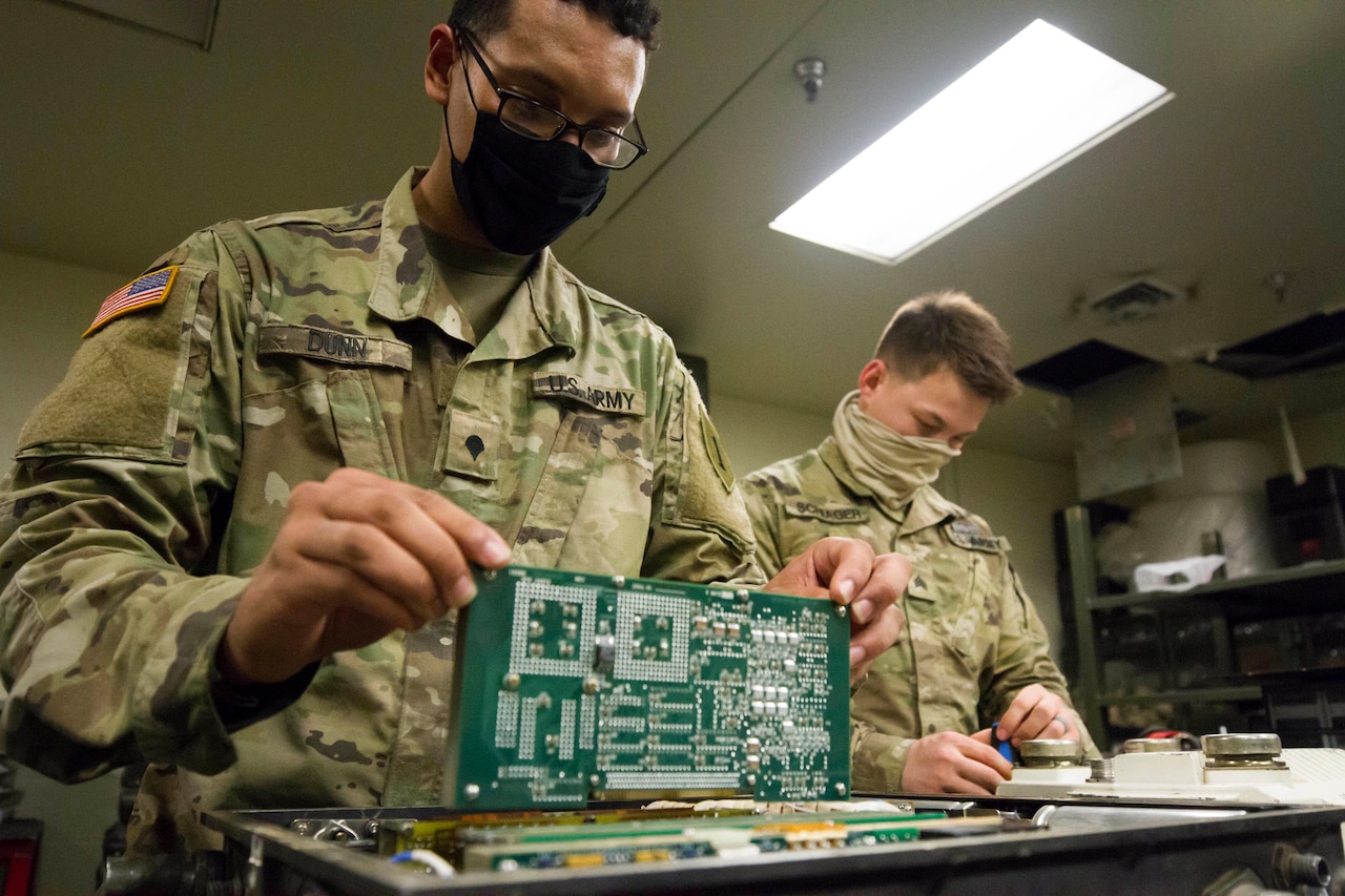 Soldiers working while wearing personal protective equipment.