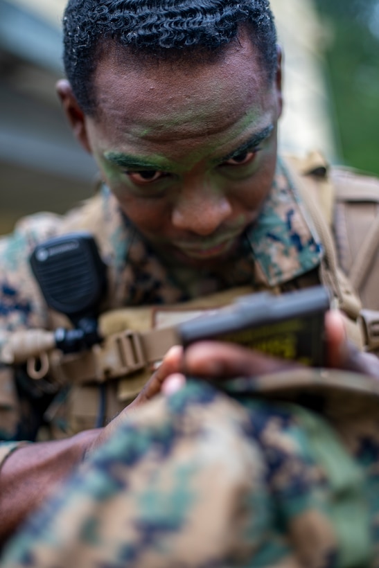 Staff Sgt. Xavier Refuge, a reconnaissance Marine with Special Purpose Marine Air-Ground Task Force - Southern Command, applies camouflage paint on his face during a field exercise at Camp Lejeune, North Carolina, May 6, 2020. These training events assist the Marines and Sailors when working alongside partner nations in Latin America and the Caribbean with crisis response preparedness, security cooperation training, and engineering projects. Refuge is a native of New Orleans, Louisiana. (U.S. Marine Corps photo by Sgt. Andy O. Martinez)