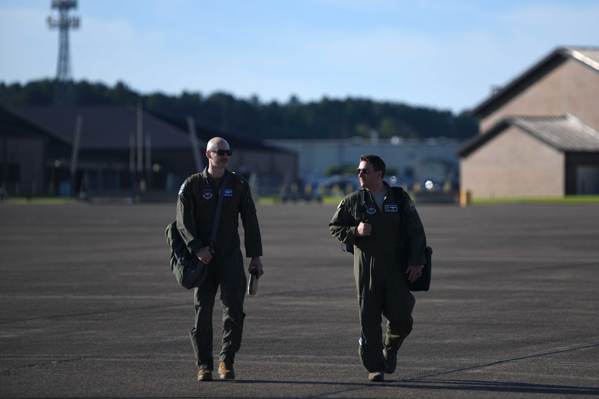 Maj. John Rebolledo and Nathan Eldredge, 62nd Airlift Squadron instructor pilots, walk towards a C-130J Super Hercules at Little Rock Air Force Base, Arkansas.