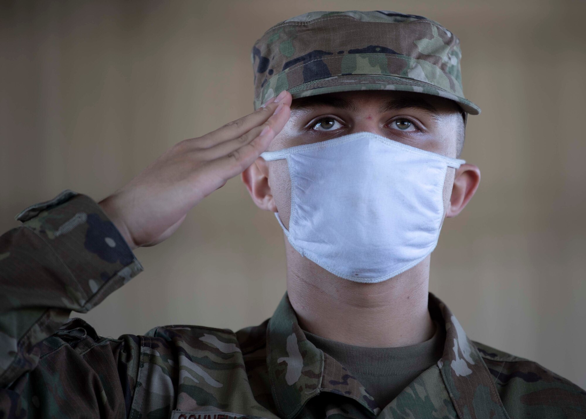 service member saluting while wearing a face covering