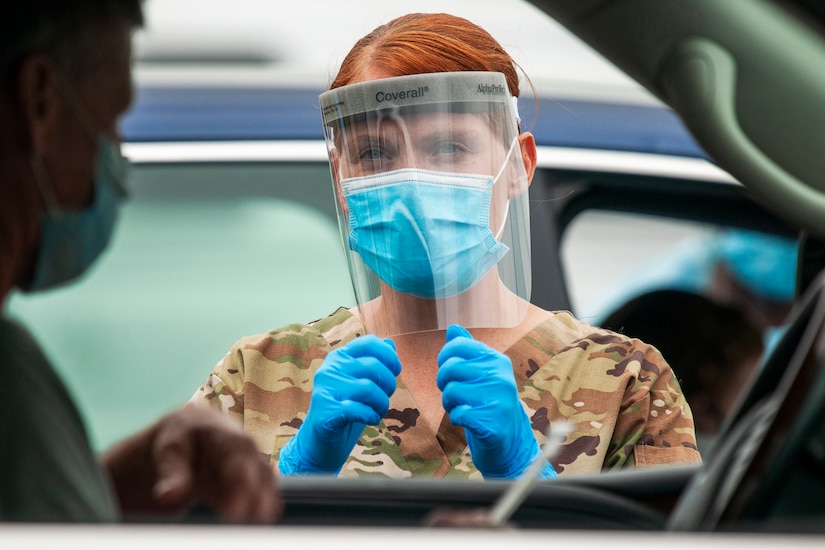 A guardsman gives instructions to drivers during a drive-thru coronavirus testing mission.