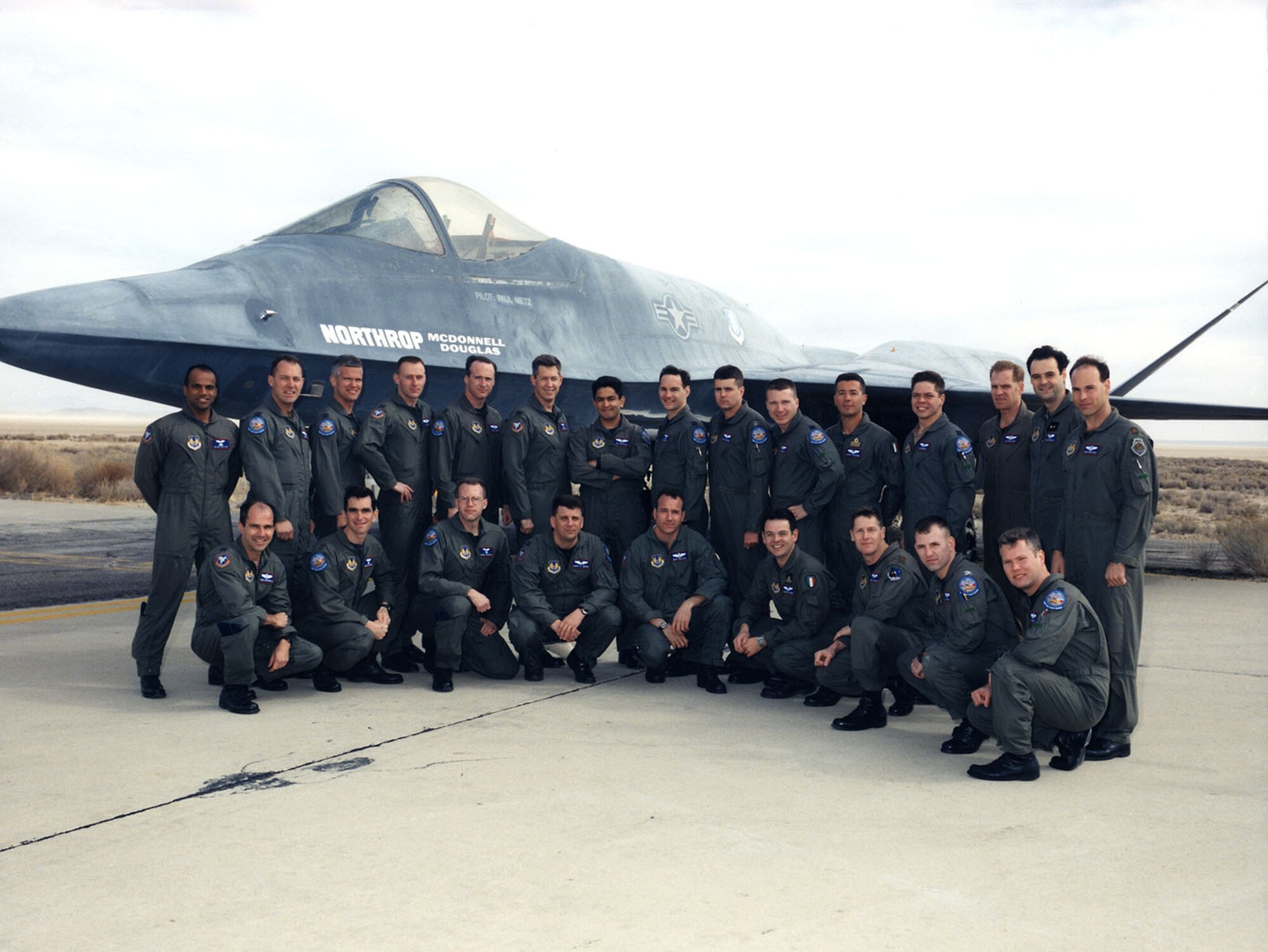 U.S. Air Force Test Pilot School class of 1998 B stand in front of a Northrop YF-23. The class included NASA pilots Jim Less and Troy Asher (top row, fourth and fifth from left). The class also included pilot Tim Williams and astronaut Robert Behnken (top row, third and fourth from right).