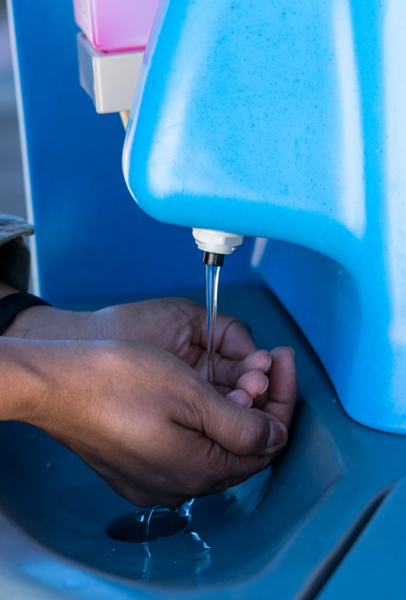A 349th Air Mobility Wing member washes their hands before entering thee headquarters building of the 349th Air Mobility Wing on May 29, 2020, at Travis Air Force Base, California. Travis Air Force Base lowered its health protection class on June 1, opening up the path for members to return to work. (U.S. Air Force photo by 2nd Lt. Daniel Phelps/Released)