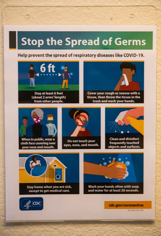A sign displaying safety messaging in regards to mitigating the spread of COVID-19 hangs in the headquarters building of the 349th Air Mobility Wing on May 29, 2020, at Travis Air Force Base, California. Travis Air Force Base lowered its health protection class on June 1, opening up the path for members to return to work. (U.S. Air Force photo by 2nd Lt. Daniel Phelps/Released)