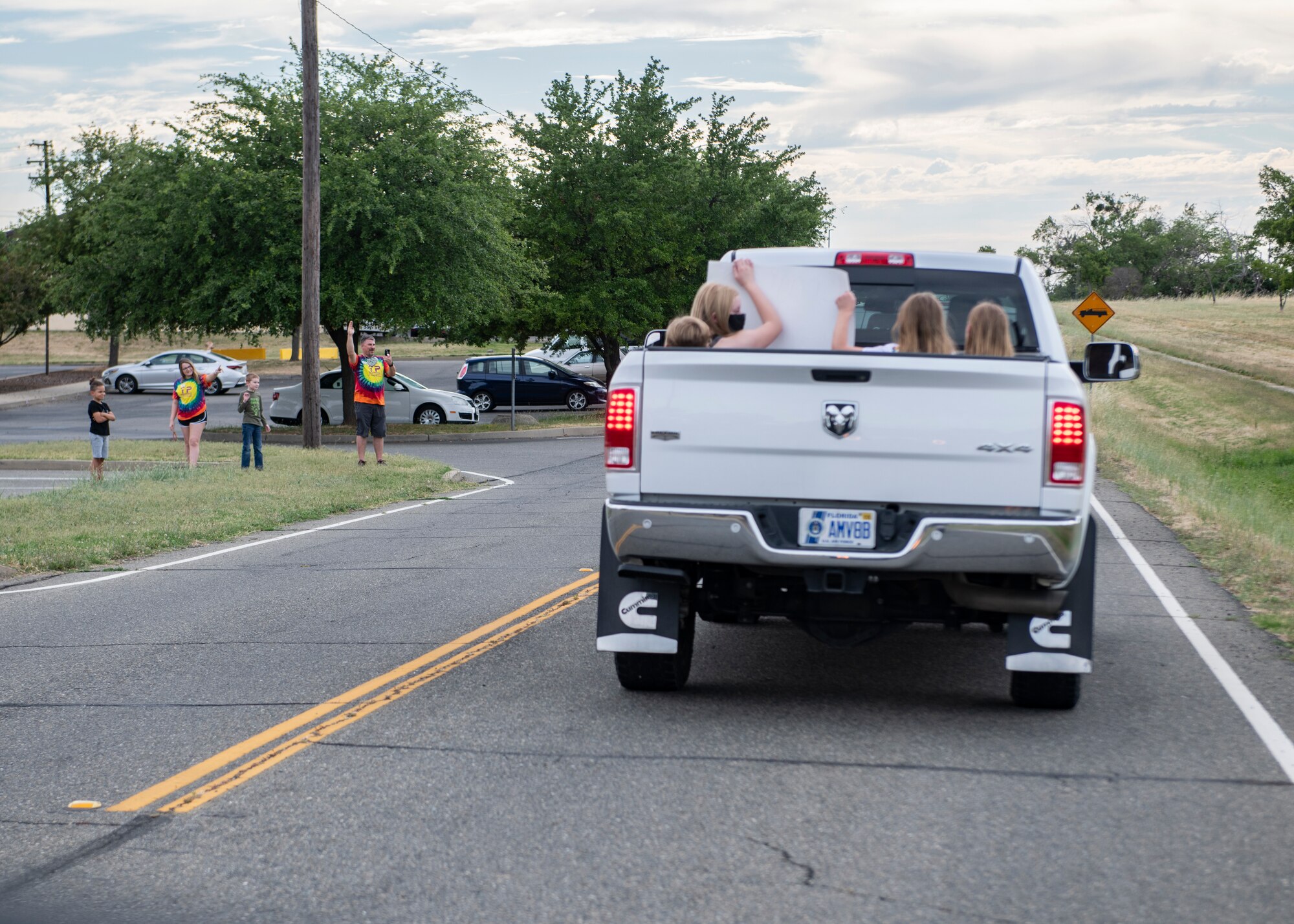 Recce Town community members wave to a parade of cars on Beale Air Force Base, California.