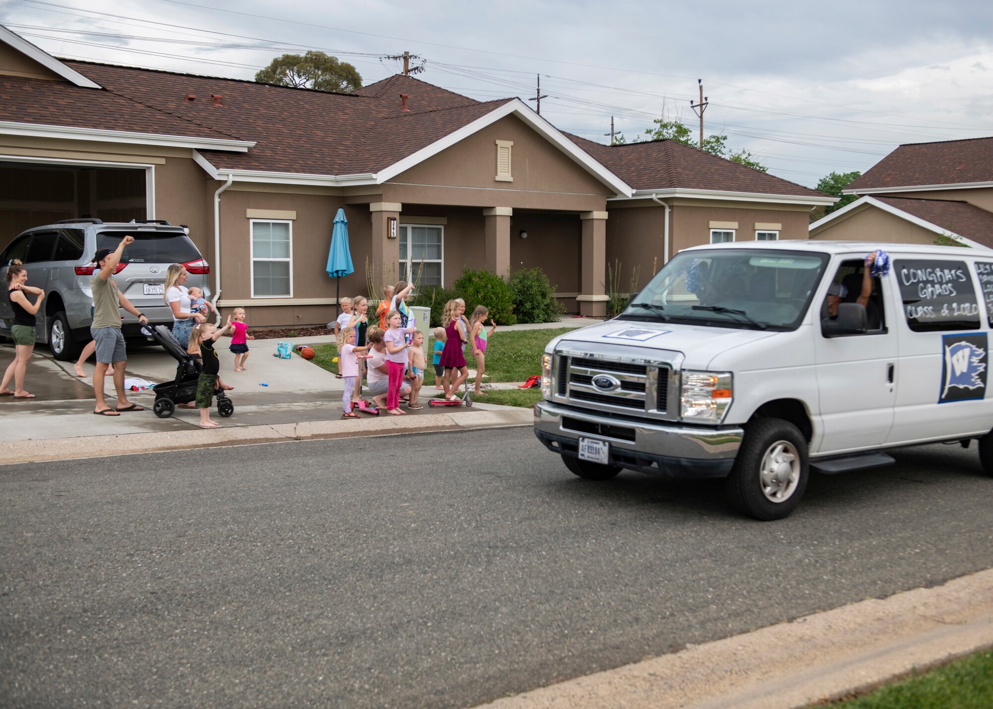 Recce Town community members wave to a parade of cars on Beale Air Force Base.