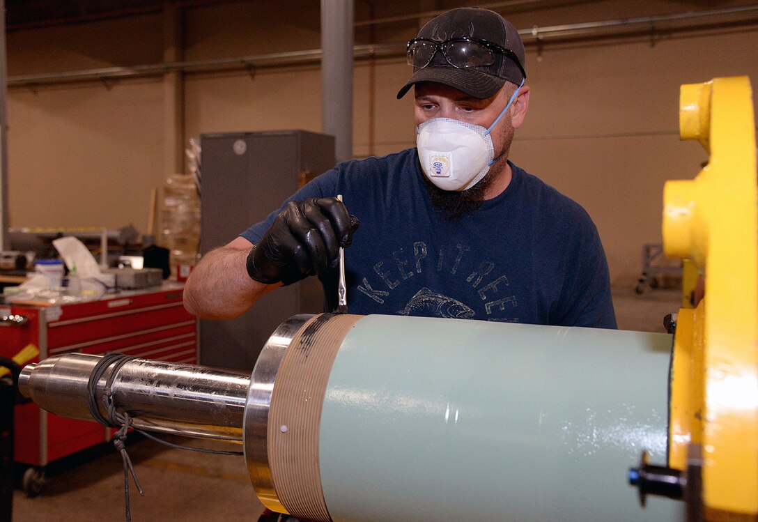 Clint Struchen, 581 Missile Maintenance Squadron powered support system mechanic, applies thread lubricant to the end of a launch control center shock isolator on Apr. 28, 2020, at Hill Air Force Base, Utah. Each LCC has four isolators used to support the floor where missile launch control personnel perform their duties.  (U.S. Air Force photo by Alex R. Lloyd)