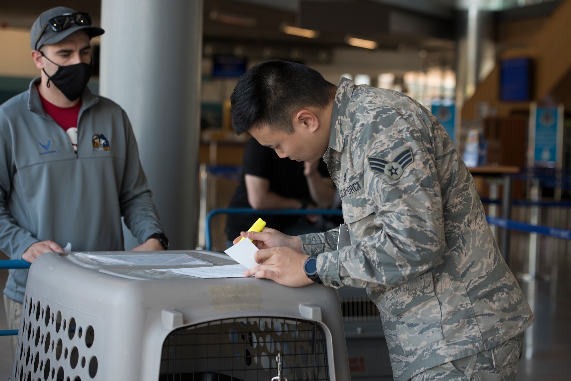 A photo of an Airmen checking documents for a passenger.