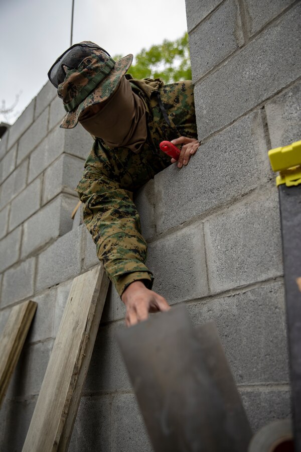 Sgt. Brian Pham, a combat engineer with Special Purpose Marine Air-Ground Task Force - Southern Command, reaches for a spade during the general exercise at Marine Corps Base Camp Lejeune, North Carolina, April 15, 2020. The GENEX includes training events such as engineering projects and evacuation control center training scenarios that will help build the SPMAGTF-SC for their final certification exercise. These training events also provide the Marines and Sailors with real-world scenarios to prepare them for their deployment to assist partner nation militaries in Latin America and the Caribbean. Pham is a native of Portland, Oregon. (U.S. Marine Corps photo by Cpl. Benjamin D. Larsen)