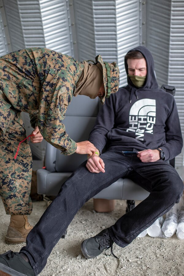 Lance Cpl. Christopher Alvarez, a combat engineer with Special Purpose Marine Air-Ground Task Force - Southern Command, removes a marking from a simulated disaster evacuee as part of an evacuation control center operation during a general exercise at Marine Corps Base Camp Lejeune, North Carolina, April 15, 2020. The GENEX includes training events such as engineering projects and evacuation control center training scenarios that will help build the SPMAGTF-SC for their final certification exercise. These training events also provide the Marines and Sailors with real-world scenarios to prepare them for their deployment to assist partner nation militaries in Latin America and the Caribbean. Alvarez is a native of Portland, Oregon. (U.S. Marine Corps photo by Cpl. Benjamin D. Larsen)