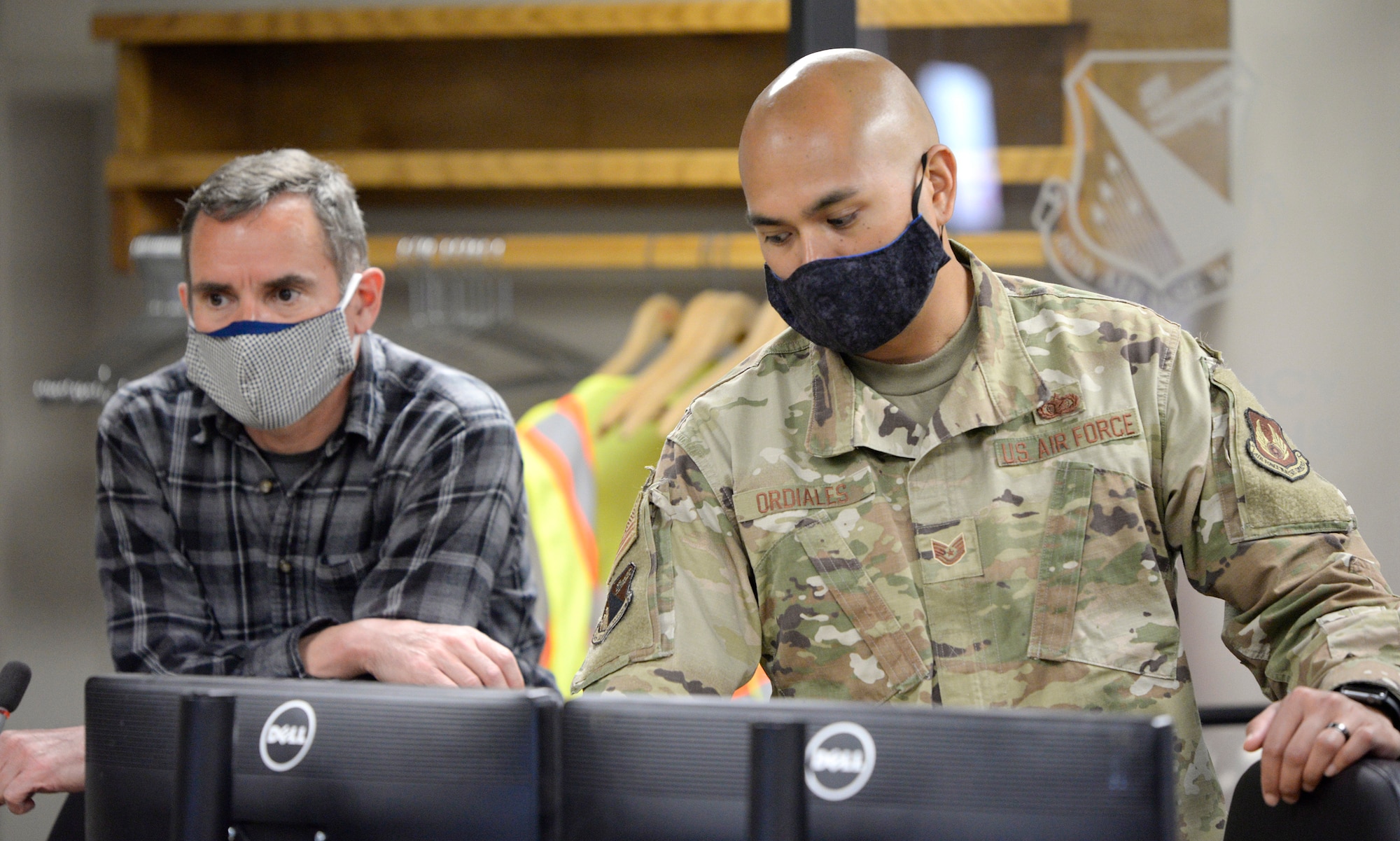 William Neitzke, left, 88th Air Base Wing Incident Command Center director of safety and planning and Tech. Sgt. Jeremy Ordiales, ICC section chief, admin cell, listen to a daily conference call with Col. Thomas P. Sherman, 88 ABW commander, while monitoring the COVID-19 pandemic at Wright-Patterson Air Force Base, Ohio, May 5, 2020. The continued use of face coverings, proper sanitation procedures and social distancing practices has enabled Wright-Patterson Air Force Base to complete three weeks of Phase I of its Return to Full Capacity plan without an increase to the number of positive COVID-19 cases reported by base medical center officials.  (U.S. Air Force photo/Ty Greenlees)