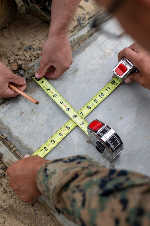 Engineers with Special Purpose Marine Air-Ground Task Force - Southern Command checks the accuracy of points on a concrete slab during a general exercise at Marine Corps Base Camp Lejeune, North Carolina, April 13, 2020. The points were used to measure the size of a wall for a building the Marines are constructing. The GENEX includes training events such as engineering projects and evacuation control center training scenarios that will help build the SPMAGTF-SC for their final certification exercise. These training events also provide the Marines and Sailors with real-world scenarios to prepare them for their deployment to assist partner nation militaries in Latin America and the Caribbean. (U.S. Marine Corps photo by Cpl. Benjamin D. Larsen)