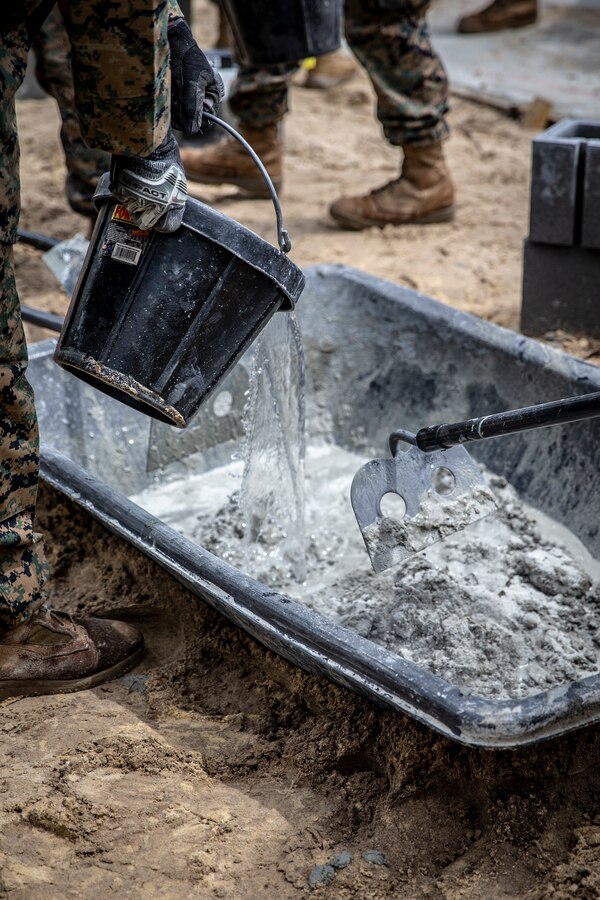 Engineers with Special Purpose Marine Air-Ground Task Force - Southern Command, stir mortar mix and water during the general exercise at Marine Corps Base Camp Lejeune, North Carolina, April 13, 2020. The Marines used mortar to create a solid base to begin construction of a building. The GENEX includes training events such as engineering projects and evacuation control center training scenarios that will help build the SPMAGTF-SC for their final certification exercise. These training events also provide the Marines and Sailors with real-world scenarios to prepare them for their deployment to assist partner nation militaries in Latin America and the Caribbean. (U.S. Marine Corps photo by Cpl. Benjamin D. Larsen)
