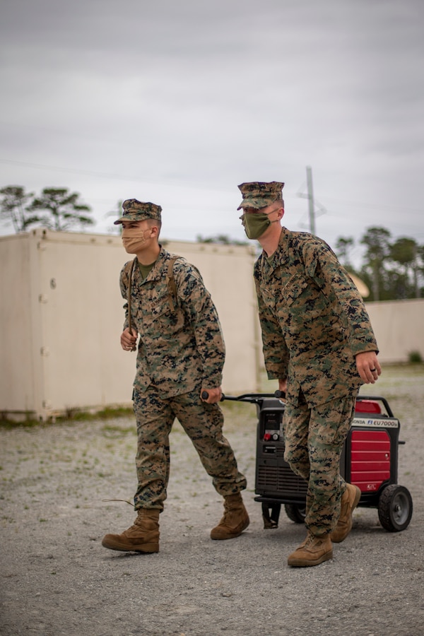 Cpl. Gennadiy Tkachuk, left, a generator mechanic, and Cpl. Justin Huxel, right, a combat engineer, both with Special Purpose Marine Air-Ground Task Force - Southern Command, deliver a generator to an evacuation control center during a certification exercise at Marine Corps Base Camp Lejeune, North Carolina, April 23, 2020. The CERTEX is the culmination exercise that will test the training and readiness of the Marines and Sailors of the SPMAGTF-SC for certification to deploy. Once certified, the SPMAGTF-SC will be ready to conduct crisis response, theater security cooperation training and general engineering projects alongside partner nation militaries in Latin America and the Caribbean. Tkachuk is a native of Hillsboro, Oregon. Huxel is a native of Independence, Oregon.  (U.S. Marine Corps photo by Cpl. Benjamin D. Larsen)