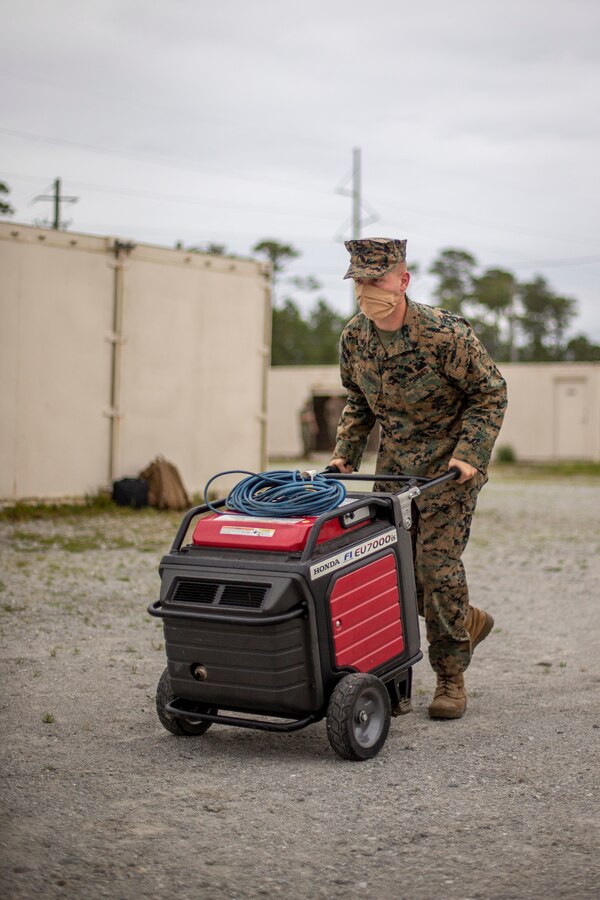 Cpl. Gennadiy Tkachuk, a generator mechanic with Special Purpose Marine Air-Ground Task Force - Southern Command, delivers a generator to an evacuation control center during a certification exercise at Marine Corps Base Camp Lejeune, North Carolina, April 23, 2020. The CERTEX is the culmination exercise that will test the training and readiness of the Marines and Sailors of the SPMAGTF-SC for certification to deploy. Once certified, the SPMAGTF-SC will be ready to conduct crisis response, theater security cooperation training and general engineering projects alongside partner nation militaries in Latin America and the Caribbean. Tkachuk is a native of Hillsboro, Oregon.  (U.S. Marine Corps photo by Cpl. Benjamin D. Larsen)