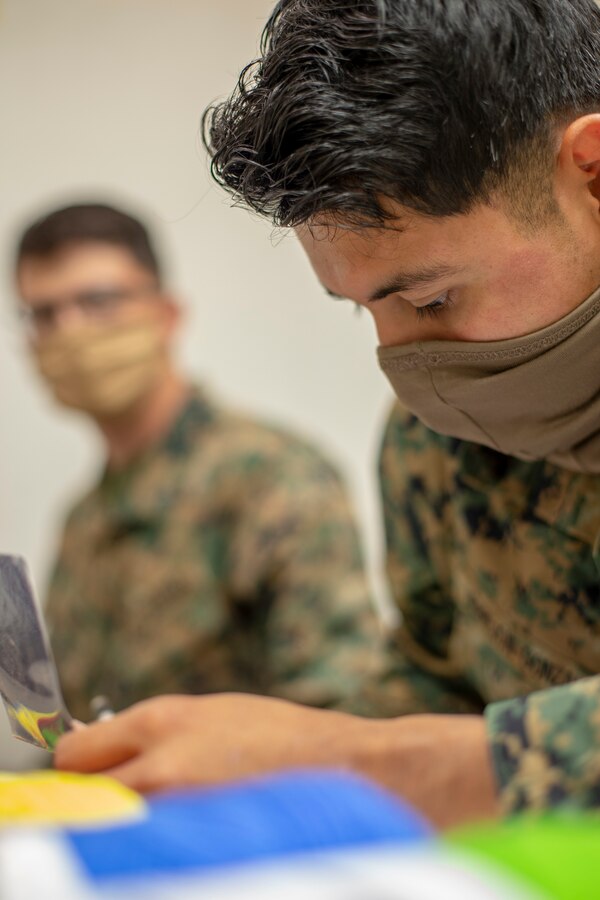 Cpl. Lawson Barnes, left, a generator mechanic, and Cpl. Eliud Herrejon, right, a combat engineer with Special Purpose Marine Air-Ground Task Force - Southern Command, inspect identification during a certification exercise at Marine Corps Base Camp Lejeune, North Carolina, April 23, 2020. The CERTEX is the culmination exercise that will test the training and readiness of the Marines and Sailors of the SPMAGTF-SC for certification to deploy. Once certified, the SPMAGTF-SC will be ready to conduct crisis response, theater security cooperation training and general engineering projects alongside partner nation militaries in Latin America and the Caribbean. Barnes is a native of Hillsboro, Oregon. Herrejon is a native of Portland, Oregon. (U.S. Marine Corps photo by Cpl. Benjamin D. Larsen)