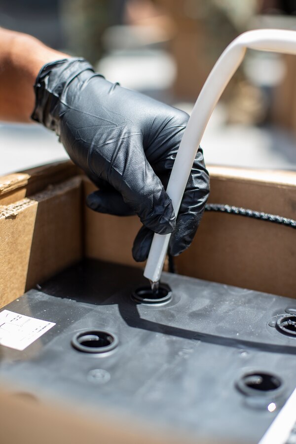 Lance Cpl. Joshua Freduluces, a landing support specialist with Special Purpose Marine Air-Ground Task Force - Southern Command, refills the components of a battery during a heavy equipment training exercise at Camp Lejeune, North Carolina, May 13, 2020. These training events assist the Marines and Sailors when working alongside partner nations in Latin America and the Caribbean with crisis response preparedness, security cooperation training, and engineering projects. Freduluces is a native of Rancho Cordova, California. (U.S. Marine Corps photo by Cpl. Benjamin D. Larsen)
