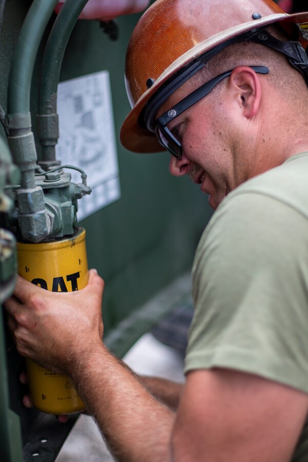 Sgt. Zack Vandehey, a heavy equipment foreman with Special Purpose Marine Air-Ground Task Force - Southern Command, unscrews an oil filter during a heavy equipment training exercise at Camp Lejeune, North Carolina, May 13, 2020. These training events assist the Marines and Sailors when working alongside partner nations in Latin America and the Caribbean with crisis response preparedness, security cooperation training, and engineering projects. Vandehey is a native of Oakland, Oregon. (U.S. Marine Corps photo by Cpl. Benjamin D. Larsen)