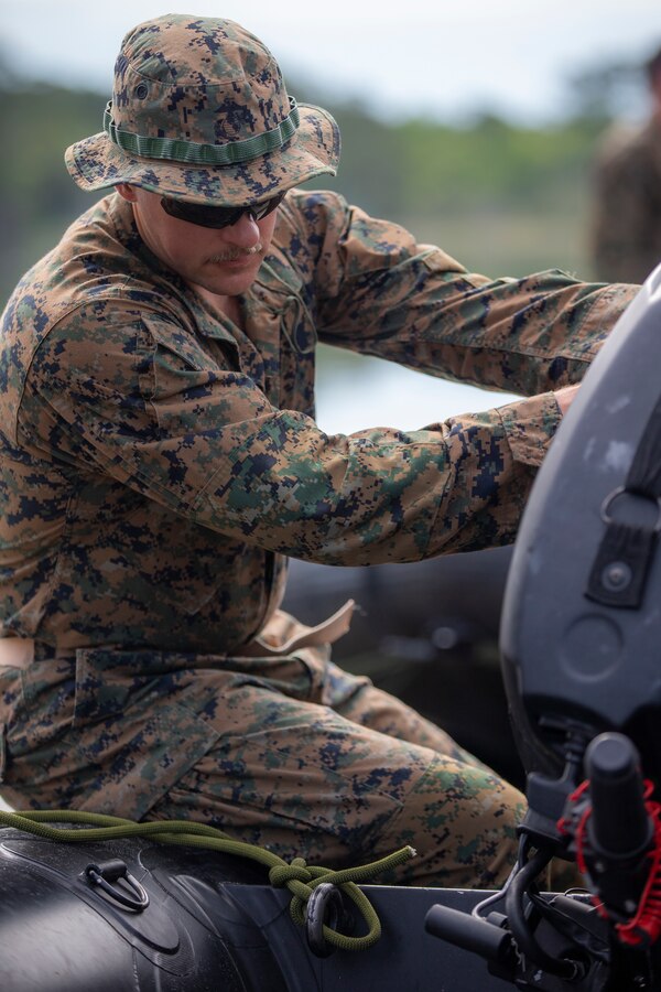 Sgt. Thomas Roeder, a military policeman with Special Purpose Marine Air-Ground Task Force - Southern Command, places an engine on a combat rubber raiding craft during a training exercise at Camp Lejeune, North Carolina, May 14, 2020. These training events assist the Marines and Sailors when working alongside partner nations in Latin America and the Caribbean with crisis response preparedness, security cooperation training, and engineering projects. Roeder is a native of Troy, Montana. (U.S. Marine Corps photo by Cpl. Benjamin D. Larsen)