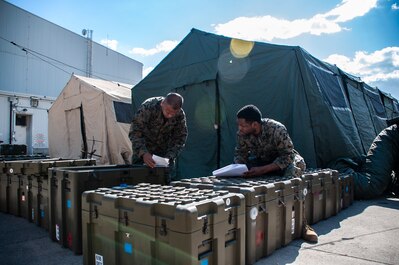 review documents during turnover of the forward resuscitative surgical system in Sigonella, Italy