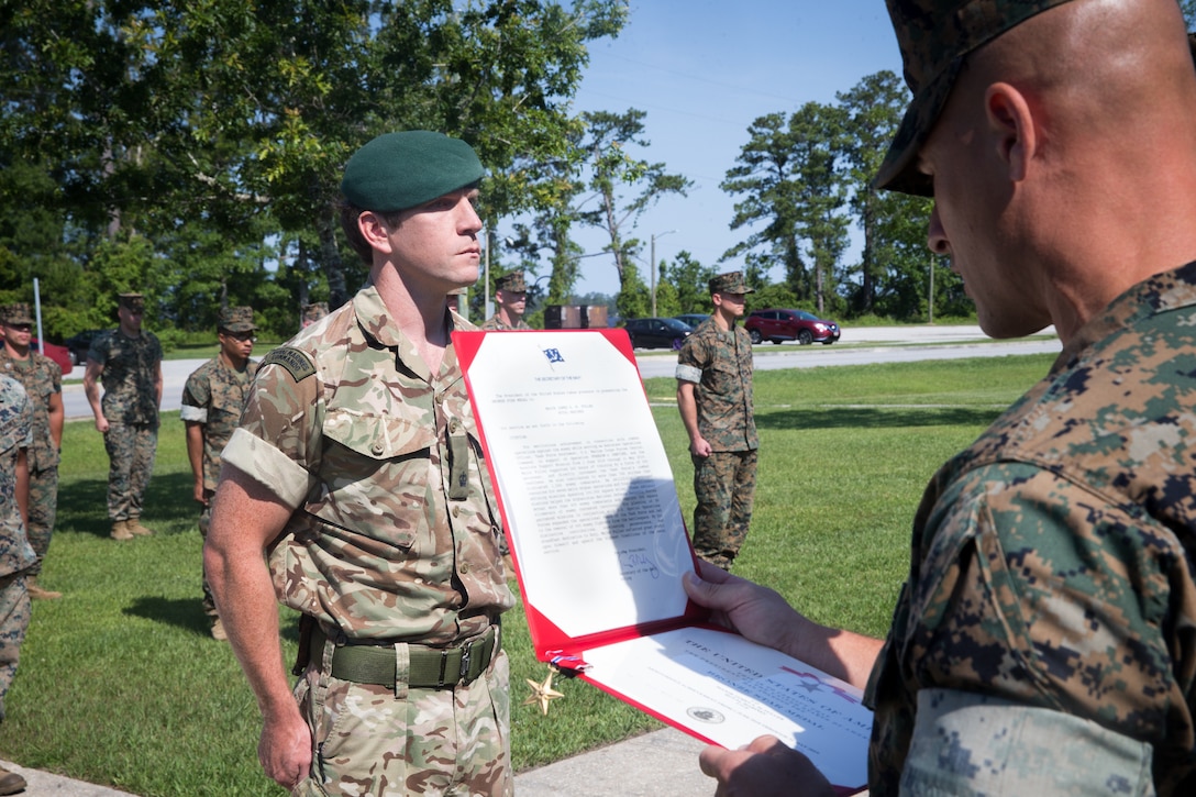 U.S. Marine Corps Col. Brian Coyne, left, commanding officer of 2d Marine Regiment, 2d Marine Division, pins a Bronze Star medal on British Royal Marine Maj. James A. Fuller, the future operations officer with 2nd Marine Regiment, at Camp Lejeune, North Carolina, June 3, 2020. Fuller received the Bronze Star for his distinctive contributions and efforts as the assistant operations officer with Task Force Southwest 19.1 (TFSW), U.S. Marine Corps Forces Central Command in Afghanistan. Fuller directly increased TSFW’s combat effectiveness and operational reach in Helmand Province. (U.S. Marine Corps photo by Lance Cpl. Jacqueline Parsons)