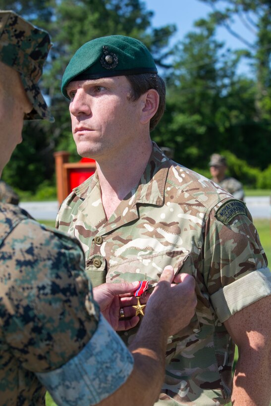 U.S. Marine Corps Col. Brian Coyne, left, commanding officer of 2d Marine Regiment, 2d Marine Division, pins a Bronze Star medal on British Royal Marine Maj. James A. Fuller, the future operations officer with 2nd Marine Regiment, at Camp Lejeune, North Carolina, June 3, 2020. Fuller received the Bronze Star for his distinctive contributions and efforts as the assistant operations officer with Task Force Southwest 19.1 (TFSW), U.S. Marine Corps Forces Central Command in Afghanistan. Fuller directly increased TSFW’s combat effectiveness and operational reach in Helmand Province. (U.S. Marine Corps photo by Lance Cpl. Jacqueline Parsons)