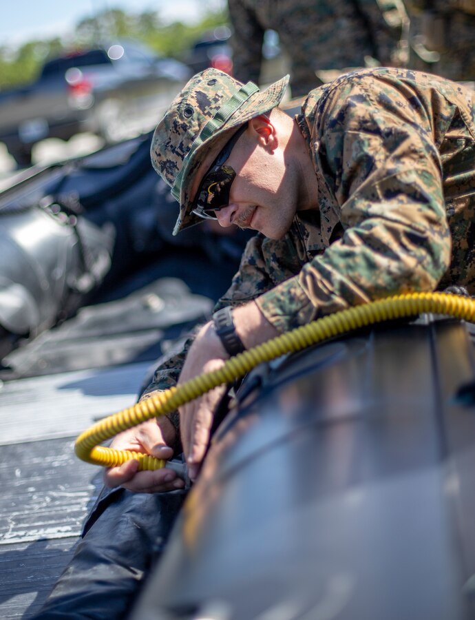Sgt. Thomas Roeder, a military policeman with Special Purpose Marine Air-Ground Task Force - Southern Command, fills a combat rubber raiding craft with air during a training exercise at Camp Lejeune, North Carolina, May 12, 2020. The Marines train and learn small boat skills and procedures to better help the SPMAGTF-SC with mission accomplishment when deployed within jungle environments. These training events assist the Marines and Sailors when working alongside partner nations in Latin America and the Caribbean with crisis response preparedness, security cooperation training, and engineering projects. Roeder is a native of Troy, Montana. (U.S. Marine Corps photo by Cpl. Benjamin D. Larsen)
