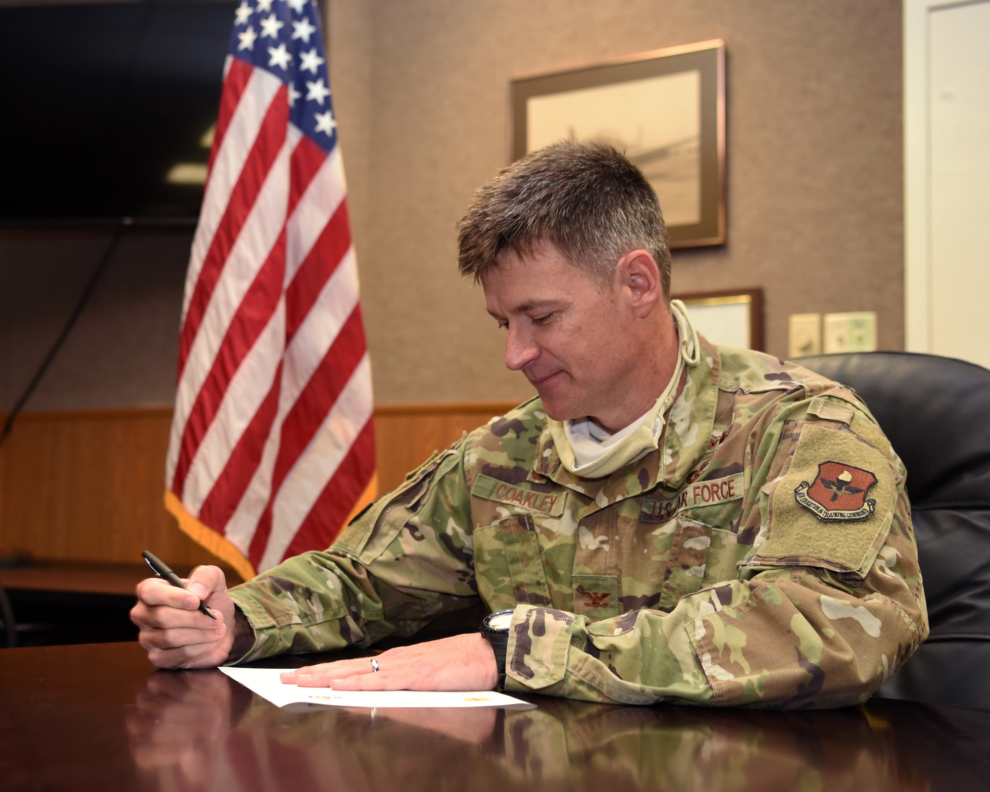 U.S. Air Force Col. Thomas Coakley, 17th Training Group commander, shows how he signs an articulation agreement amendment to an existing 2013 agreement between Angelo State University and the 17 TRG, during the COVID-19 pandemic, in the Brandenburg Hall on Goodfellow Air Force Base, Texas, June 2, 2020. The amended agreement allowed the 14N Intelligence Officer course graduates to transfer up to 12 semester hours towards three different ASU graduate programs for free. (U.S. Air Force photo by Airman 1st Class Abbey Rieves)