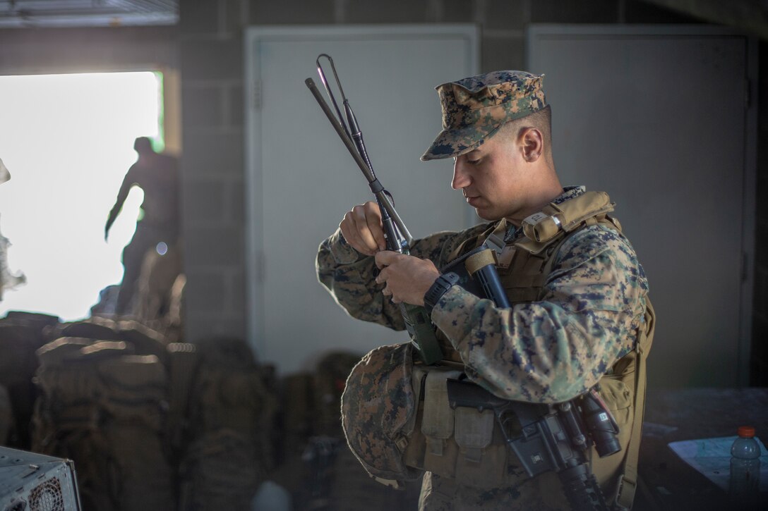 Sgt. Jose Labra Escudero, a field radio operator with Special Purpose Marine Air-Ground Task Force - Southern Command, prepares radios for a mock raid during a field exercise at Camp Lejeune, North Carolina, May 7, 2020. The Marines train and perform a variety of infantry skill evaluations during the field exercise to help sharpen their overall capabilities. These training events assist the Marines and Sailors when working alongside partner nations in Latin America and the Caribbean with crisis response preparedness, security cooperation training, and engineering projects. Labra Escudero is a native of Greensboro, North Carolina. (U.S. Marine Corps photo by Cpl. Benjamin D. Larsen)