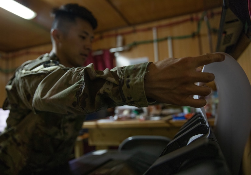 Staff Sgt. Nhia Xiong prepares to print a tactical map in his office while he is deployed to the Middle East with the Headquarters & Headquarters Company, 34th Expeditionary Combat Aviation Brigade. His role as the geospatial non-commissioned officer in charge is to oversee the creation and printing of maps used by other units in his area of operations for missions that support of Operation Spartan Shield and Operation Inherent Resolve.