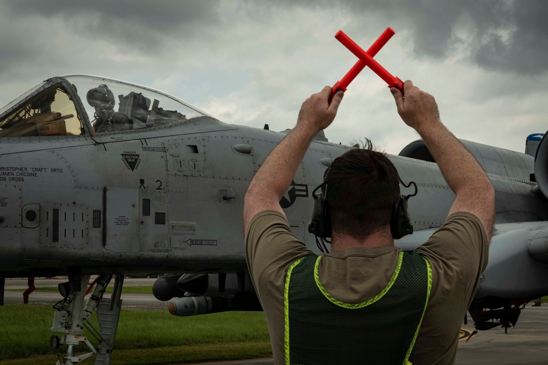 Photo of an Airman marshalling an A-10C Thunderbolt II.