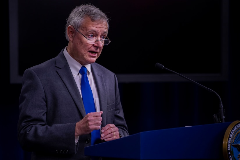 A man stands behind a lectern.