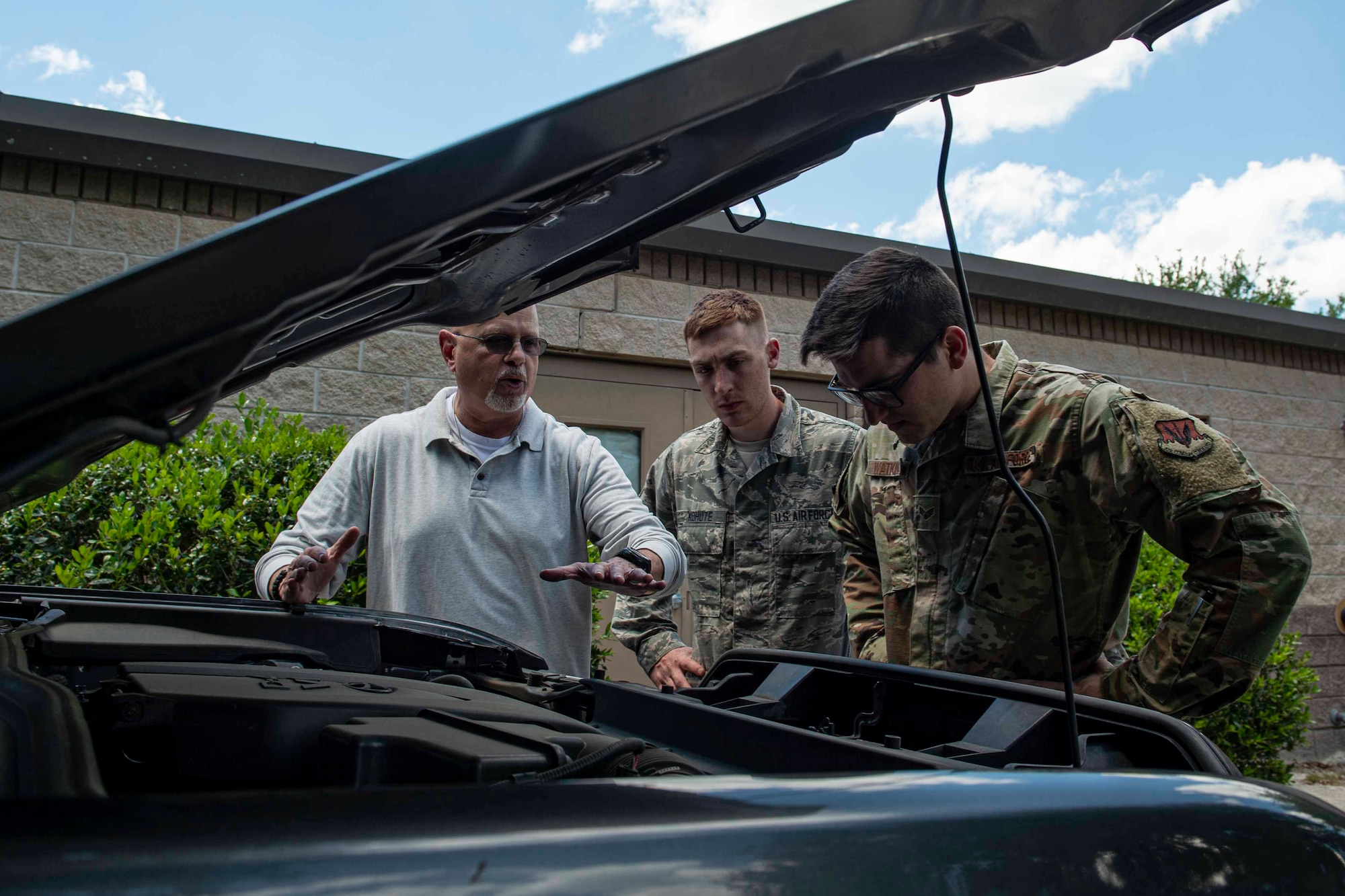 Photo of an Airman explaining how to search a vehicle.