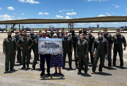 T-6 pilots assigned to the 340th Flying Training Group's 39th Flying Training Squadron and the 12th Flying Training Wing's 559th FTS gathered to honor retiring Joint Base San Antonio-Randolph, Texas T-6 maintainer Carl Powers (pictured here holding his farewell memento with his wife Arlene). Powers retired May 31 after nearly 50 years of uniformed and civilian service. (U.S. Air Force photo)